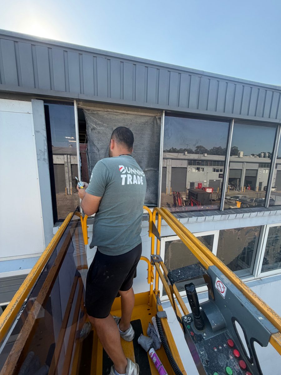 Glazier replacing high-level window glass from a scissor lift near Flinders View